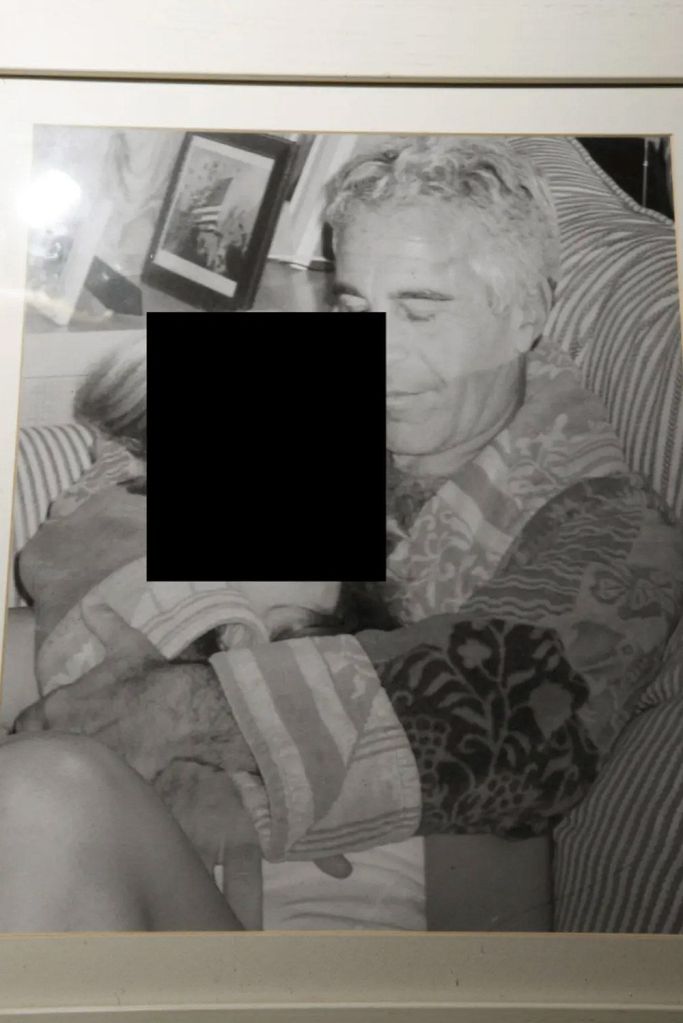 Epstein holding an unidentified young girl while dressed in a robe.